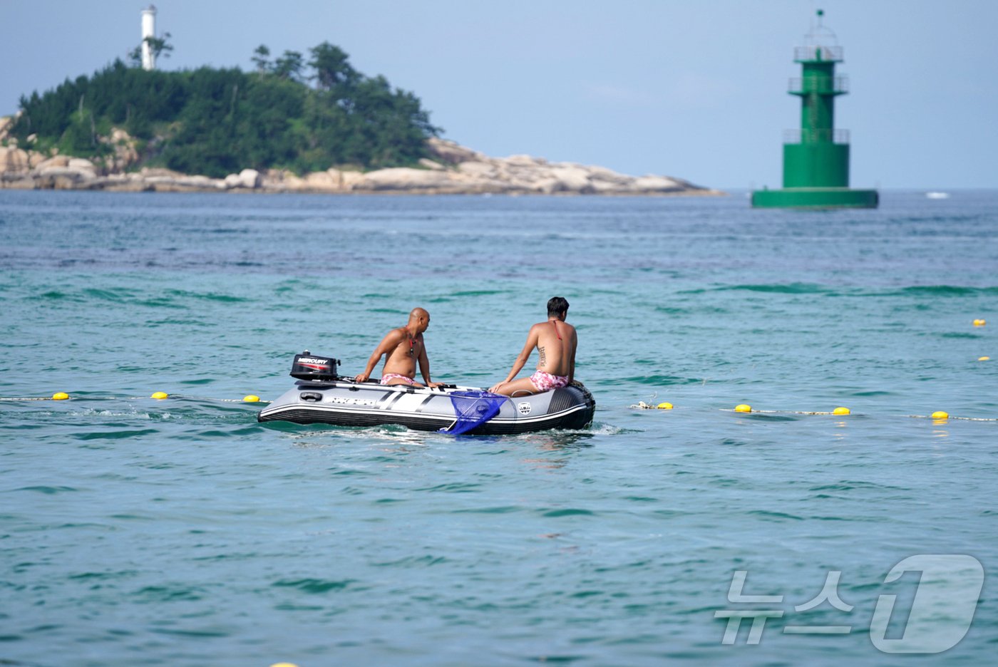 본문 이미지 - 속초해수욕장에 설치된 해파리·상어 방지 그물망 뒤로 수상안전요원들이 해파리 채집을 위해 순찰 중이다.(속초시 제공) 2024.8.1/뉴스1