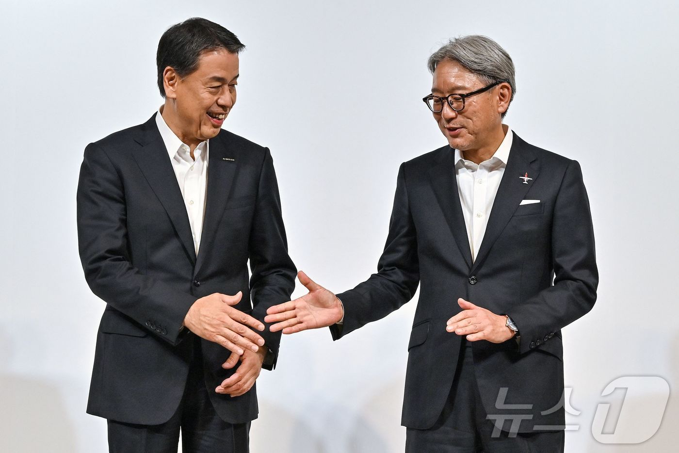 본문 이미지 - 우치다 마코토 닛산 사장과 마베 도시히로 혼다 사장이 1일(현지시각) 도쿄에서 열린 기자회견을 마친 뒤 악수를 하고 있다. 2024.08.02 ⓒ AFP=뉴스1 ⓒ News1 우동명 기자