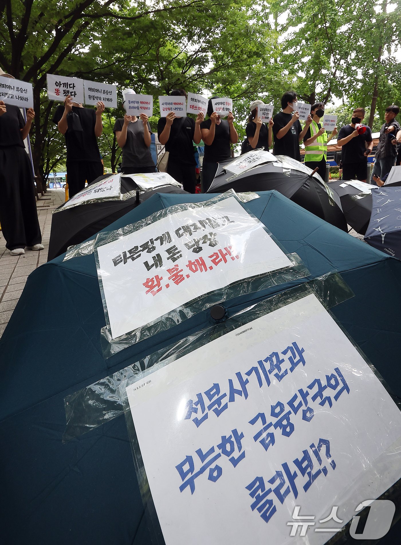 2일 오후 서울 영등포구 여의도 금융감독원 앞에서 티몬·위메프 정산·환불 지연 사태로 사실상 사용이 정지된 해피머니 상품권 피해자들이 사태 해결을 촉구하는 우산 시위를 하고 있다.. 2024.8.2/뉴스1 ⓒ News1 김진환 기자