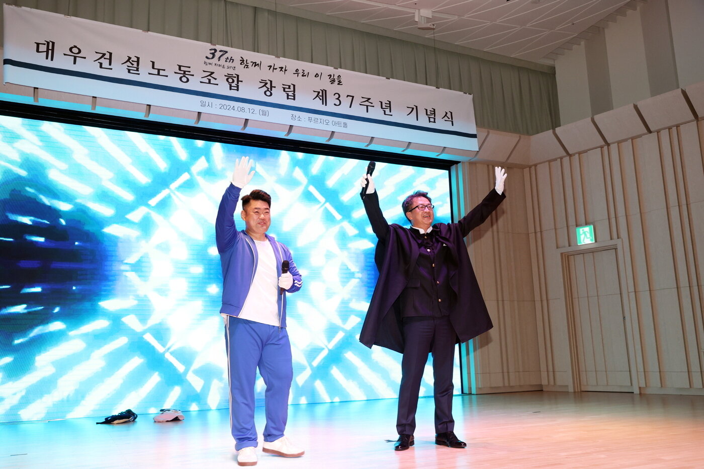 본문 이미지 - 12일 열린 대우건설 조합창립 기념식에서 백정완 대우건설 사장(사진 오른쪽)과 심상철 노조위원장(왼쪽)이 복면가왕 이벤트에서 특별공연을 보여주고 있다.(대우건설 제공)