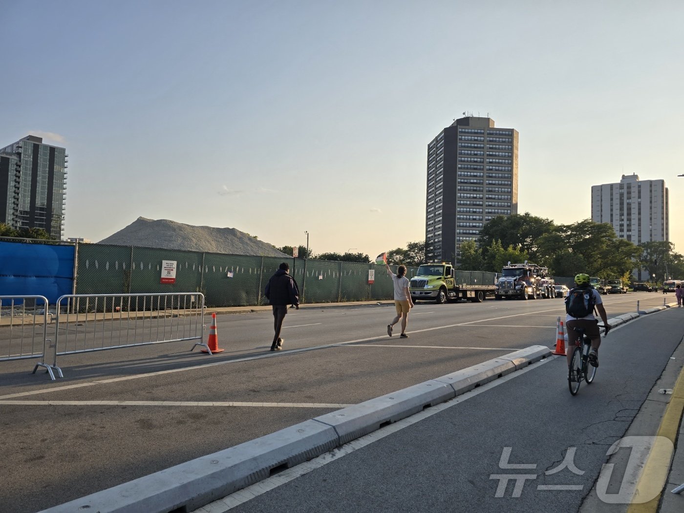 본문 이미지 - 19일(현지시간) 미국 민주당 전당대회가 열리는 일리노이주 시카고 소재 유나이티드센트 인근에서 한 아랍계 남성((왼쪽에서 두번째) 팔레스타인 국기를 흔들며 지나가고 있다. 그는 "민주당 엿 먹어라"를 연신 외치며 바이든-해리스 행정부의 이스라엘 지원을 비난했다.