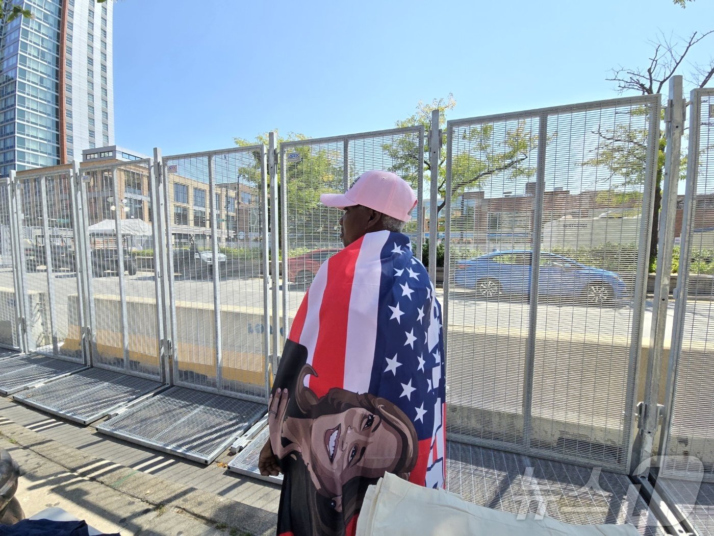 본문 이미지 - 19일(현지시간) 미 민주당 전당대회가 열리는 유나이티드센터 인근에서 만난 샤론 진(63)씨가 카멀라 해리스 민주당 대통령 후보가 새겨진 성조기를 두르고 서 있다.