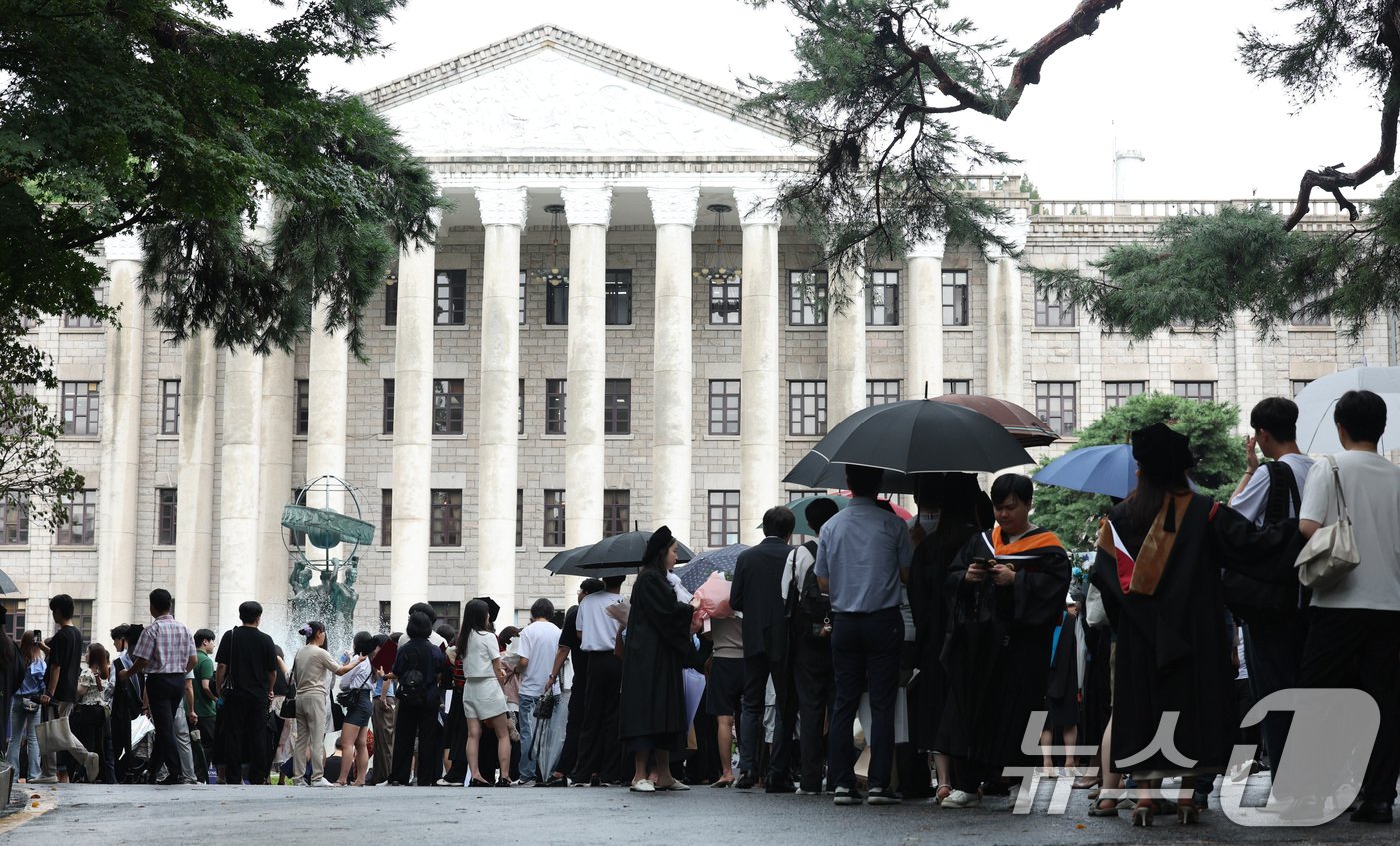 본문 이미지 - 21일 서울 동대문구 경희대학교에서 열린 2023학년도 후기 학위수여식에서 졸업생과 가족, 친구들이 포토존 기념 촬영을 하기 위해 줄을 서 있다. 2024.8.21/뉴스1 ⓒ News1 신웅수 기자