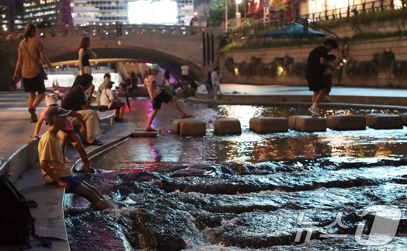 본문 이미지 - 열대야가 이어지는 21일 오후 서울 청계천을 찾은 시민들과 외국인 관광객들이 더위를 식히고 있다. 2024.8.21/뉴스1 ⓒ News1 박세연 기자