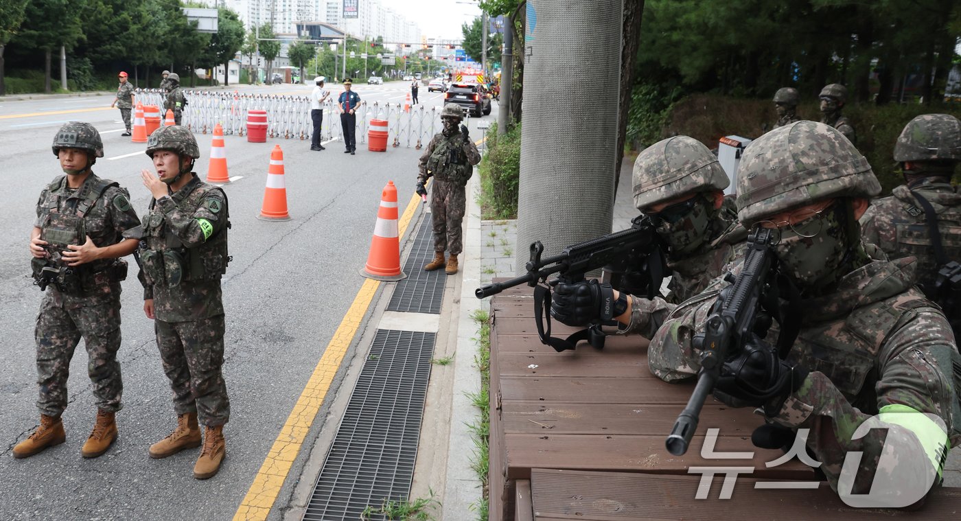 22일 오후 서울 도봉구 자원순환센터 앞에서 열린 2024년 을지연습 공습대비 민방위훈련 중 군경합동 교통통제소 설치훈련에서 수도방위사령부 56보병사단 용마여단 장병들이 바리게이트를 설치 후 경계를 서고 있다. 2024.8.22/뉴스1 ⓒ News1 김명섭 기자