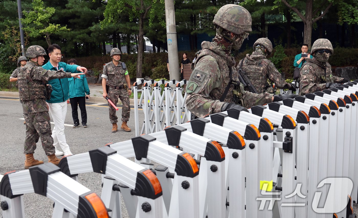본문 이미지 - 22일 오후 서울 도봉구 자원순환센터 앞에서 열린 2024년 을지연습 공습대비 민방위훈련 중 군경합동 교통통제소 설치훈련에서 수도방위사령부 56보병사단 용마여단 장병들이 바리게이트를 설치하고 있다. 2024.8.22/뉴스1 ⓒ News1 김명섭 기자