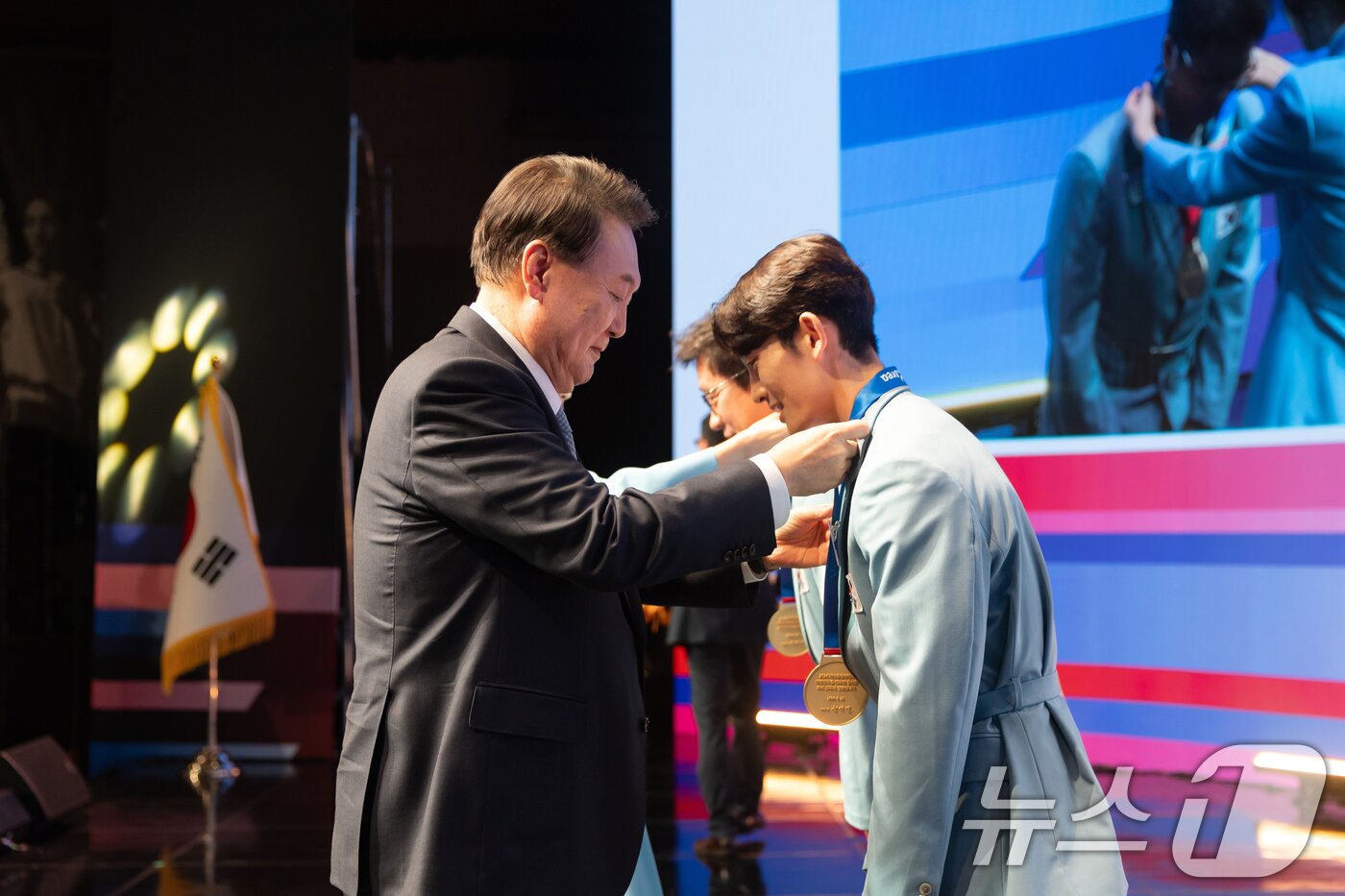 본문 이미지 - 윤석열 대통이 22일 서울 중구 신라호텔에서 열린 &#39;2024 파리올림픽 선수단 격려 행사&#39;에서 스포츠클라이밍 스피드 종목에 출전한 신은철 선수&#40;오른쪽&#41;, 근대5종 동메달을 획득한 성승민 선수를 지도한 김성진 코치에게 직접 메달을 수여하고 있다. &#40;대통령실 제공&#41; 2024.8.22/뉴스1 ⓒ News1 송원영 기자