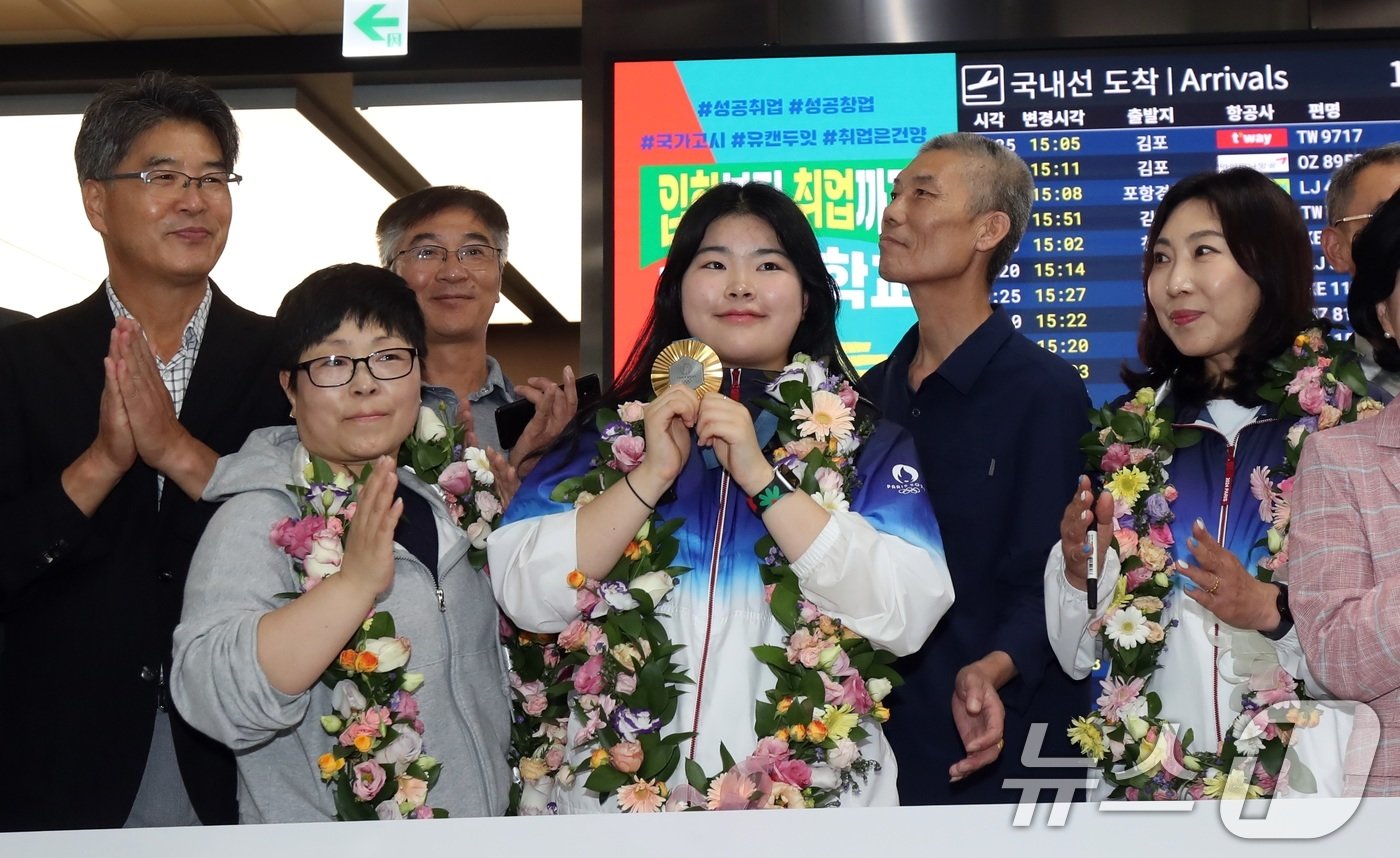 본문 이미지 - 24일 고향 제주를 찾은 파리올림픽 여자 공기권총 10m부문 금메달리스트 오예진(19·IBK기업은행) 선수가 제주국제공항에서 도청 및 도 체육회 관계자 등과 기념촬영을 하고 있다.2024.8.24/뉴스1 ⓒ News1 고동명 기자
