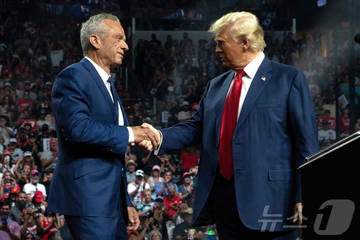 본문 이미지 - 미국 공화당 대선후보인 도널드 트럼프 전 대통령이 23일&#40;현지시간&#41; 애리조나주 글렌데일에서 열린 선거 집회서 트럼프 전 대통령 지지를 선언하며 사퇴한 무소속 후보 로버트 케네디 주니어와 악수를 하고 있다. 2024.08.25 ⓒ AFP=뉴스1 ⓒ News1 우동명 기자
