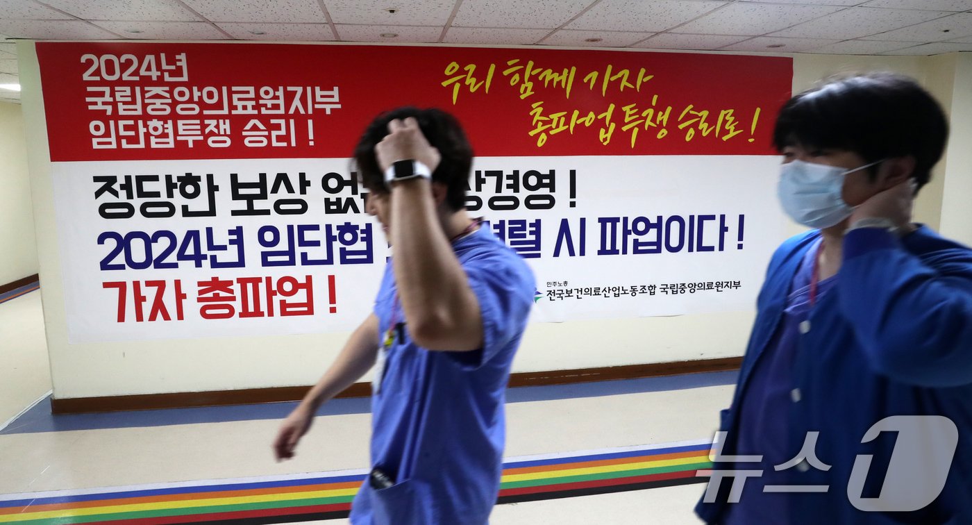 본문 이미지 - 보건의료노조 국립중앙의료원지부 노조원들이 26일 서울 중구 국립중앙의료원 앞에서 열린 총파업 투쟁 선전전을 마치고 본관에 걸린 대형 투쟁 현수막 앞을 지나고 있다. 2024.8.26/뉴스1 ⓒ News1 박세연 기자