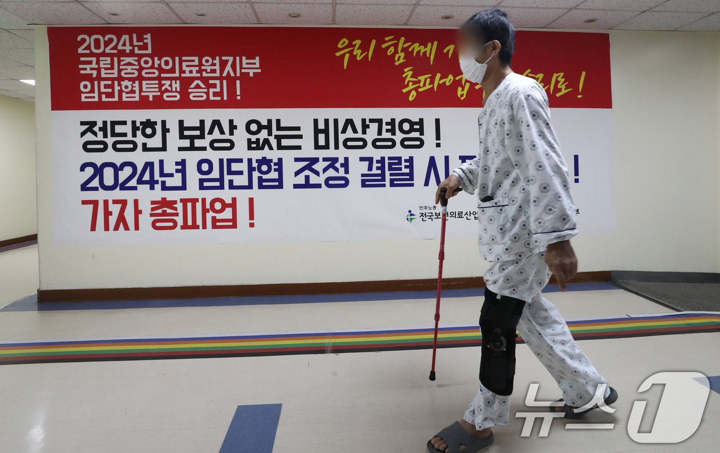 본문 이미지 - 26일 서울 중구 국립중앙의료원에서 한 환자가 총파업 투쟁 현수막 앞을 지나고 있다.2024.8.26./뉴스1 ⓒ News1 박세연 기자