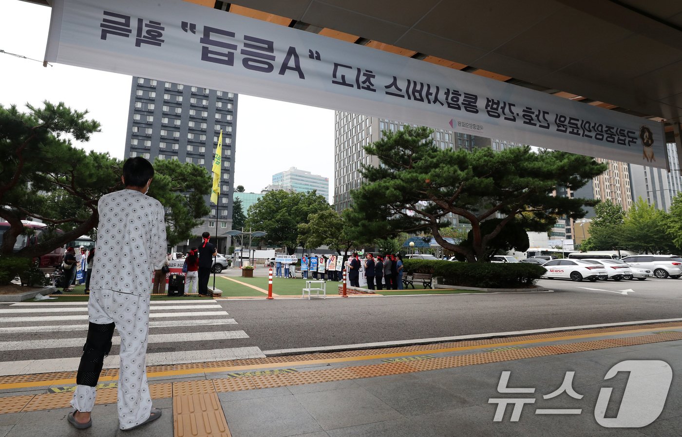 26일 한 환자가 서울 중구 국립중앙의료원 앞에서 열린 보건의료노조 국립중앙의료원지부 노조 총파업 투쟁 선전전을 바라보고 있다. .2024.8.26/뉴스1 ⓒ News1 박세연 기자