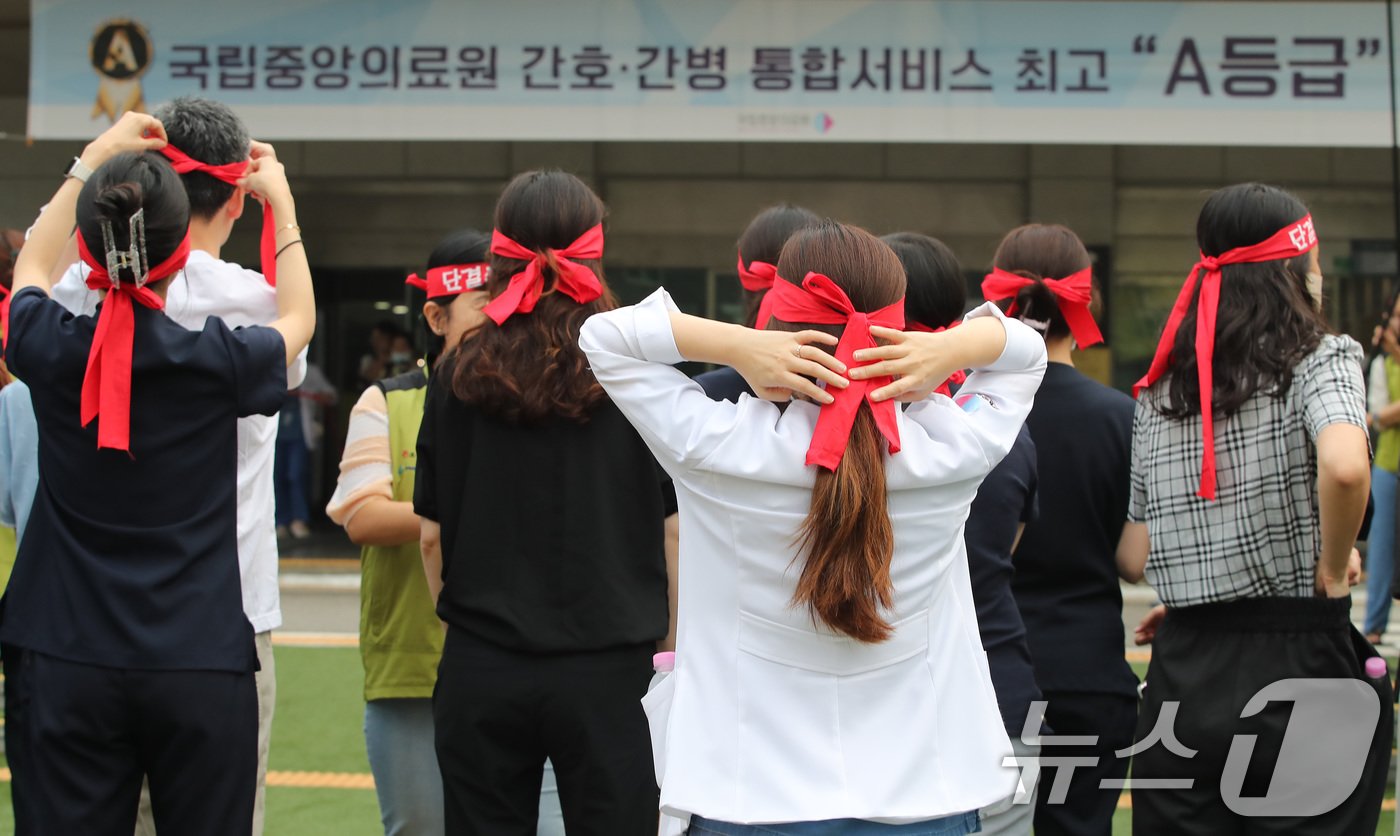 보건의료노조 국립중앙의료원지부 노조원들이 26일 서울 중구 국립중앙의료원에서 열린 총파업 투쟁 선전전에 참석하며 투쟁 머리띠를 묶고 있다.2024.8.26/뉴스1 ⓒ News1 박세연 기자