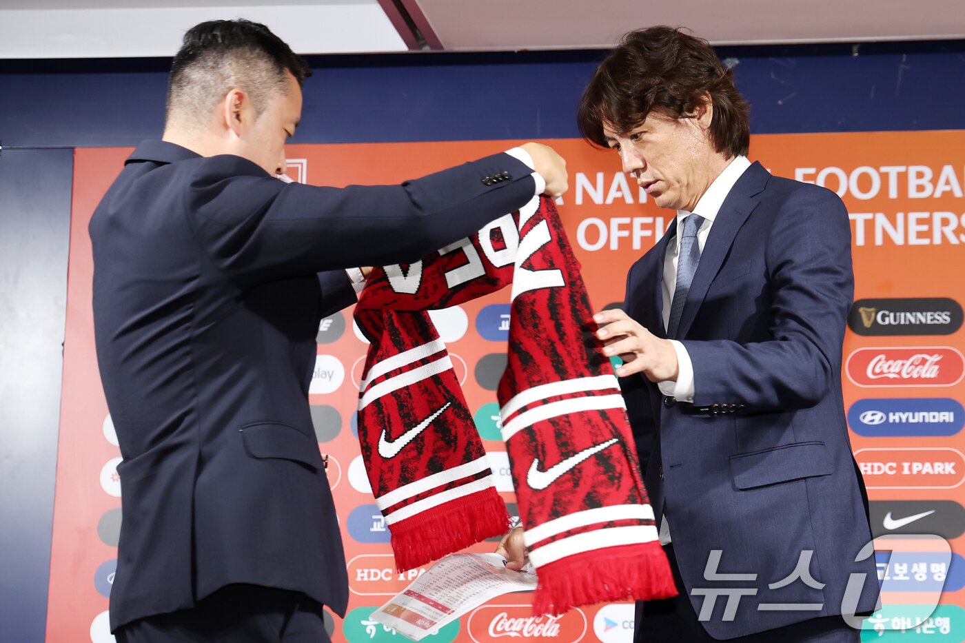 홍명보 대한민국 축구 국가대표팀 감독이 26일 오전 서울 종로구 축구회관에서 열린 &#39;2026 북중미 월드컵 아시아지역 3차 예선 대표팀 소집 명단 발표 기자회견&#39;이 끝난 뒤 머플러를 건네받고 있다. 홍명보호 1기는 9월 5일 오후 8시 서울월드컵경기장에서 팔레스타인과 월드컵 예선 1차전을 치르고, 이후 오만으로 건너가 10일 오후 11시&#40;한국시간&#41; 무스카트 술탄 카부스 스타디움에서 오만과 2차전을 펼친다. 2024.8.26/뉴스1 ⓒ News1 민경석 기자