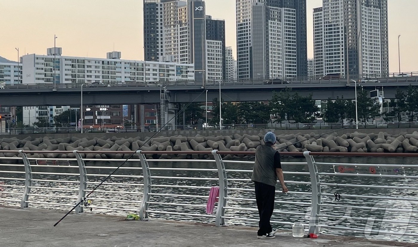 본문 이미지 - 26일 오후 한 시민이 부산 남구 용호동 해안먹거리타운에서 낚시를 하고 있다.2024.8.26/ⓒ News1 장광일 기자