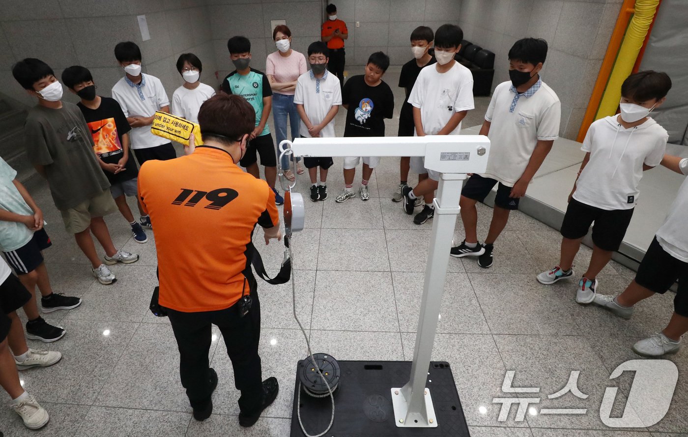 본문 이미지 - 배문중학교 학생들이 27일 서울 동작구 보라매안전체험관에서 완강기 사용방법을 배우고 있다. 19명의 사상자가 발생한 부천 호텔 화재 후 완강기에 대한 관심이 높아지고 있다. 2024.8.27/뉴스1 ⓒ News1 박세연 기자
