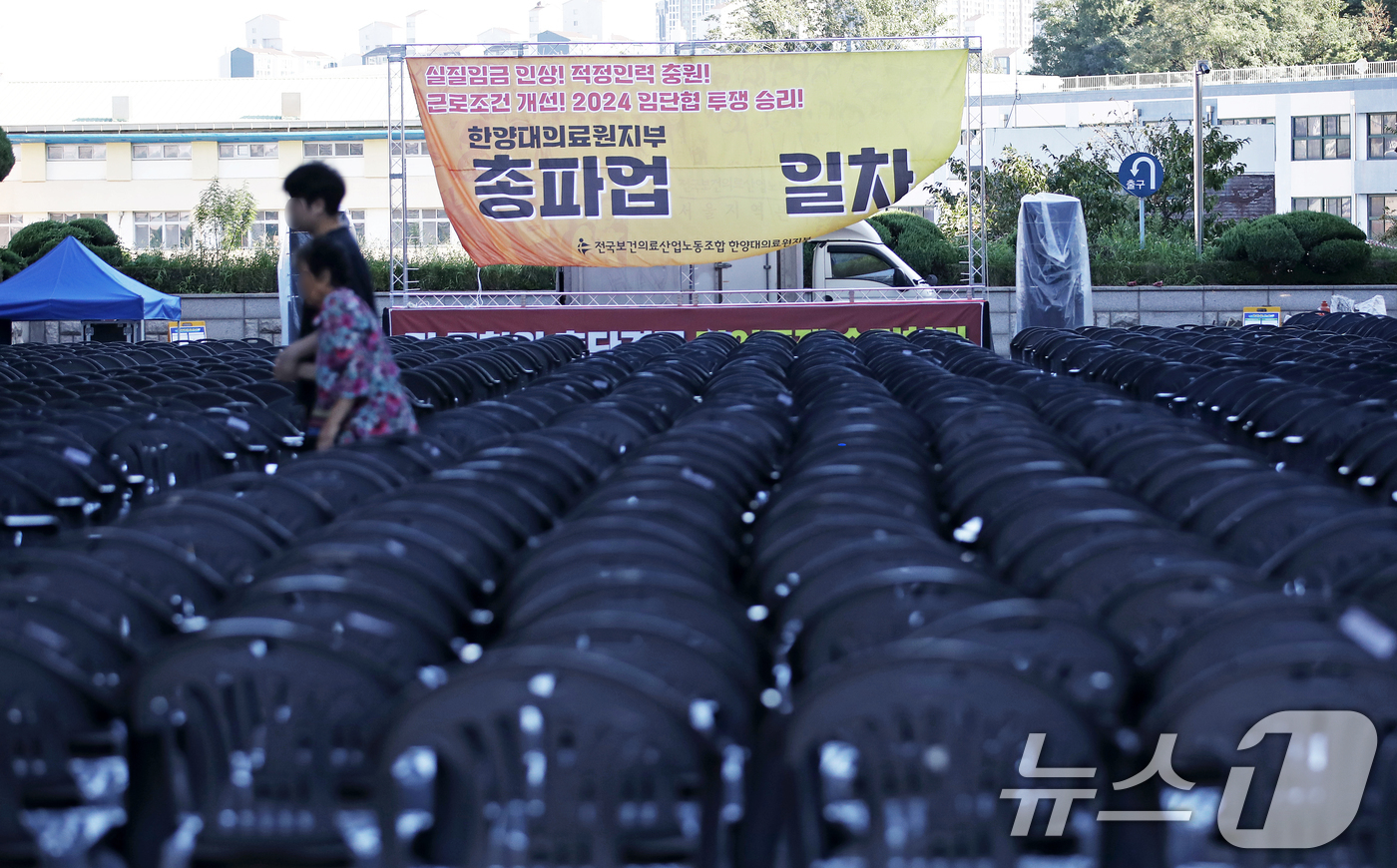 (서울=뉴스1) 오대일 기자 = 보건의료노조가 총파업을 사실상 철회한 29일 오전 서울 성동구 한양대병원에서 한 환자와 보호자가 파업 독려 현수막이 걸린 노조의 총파업 행사장 사이 …