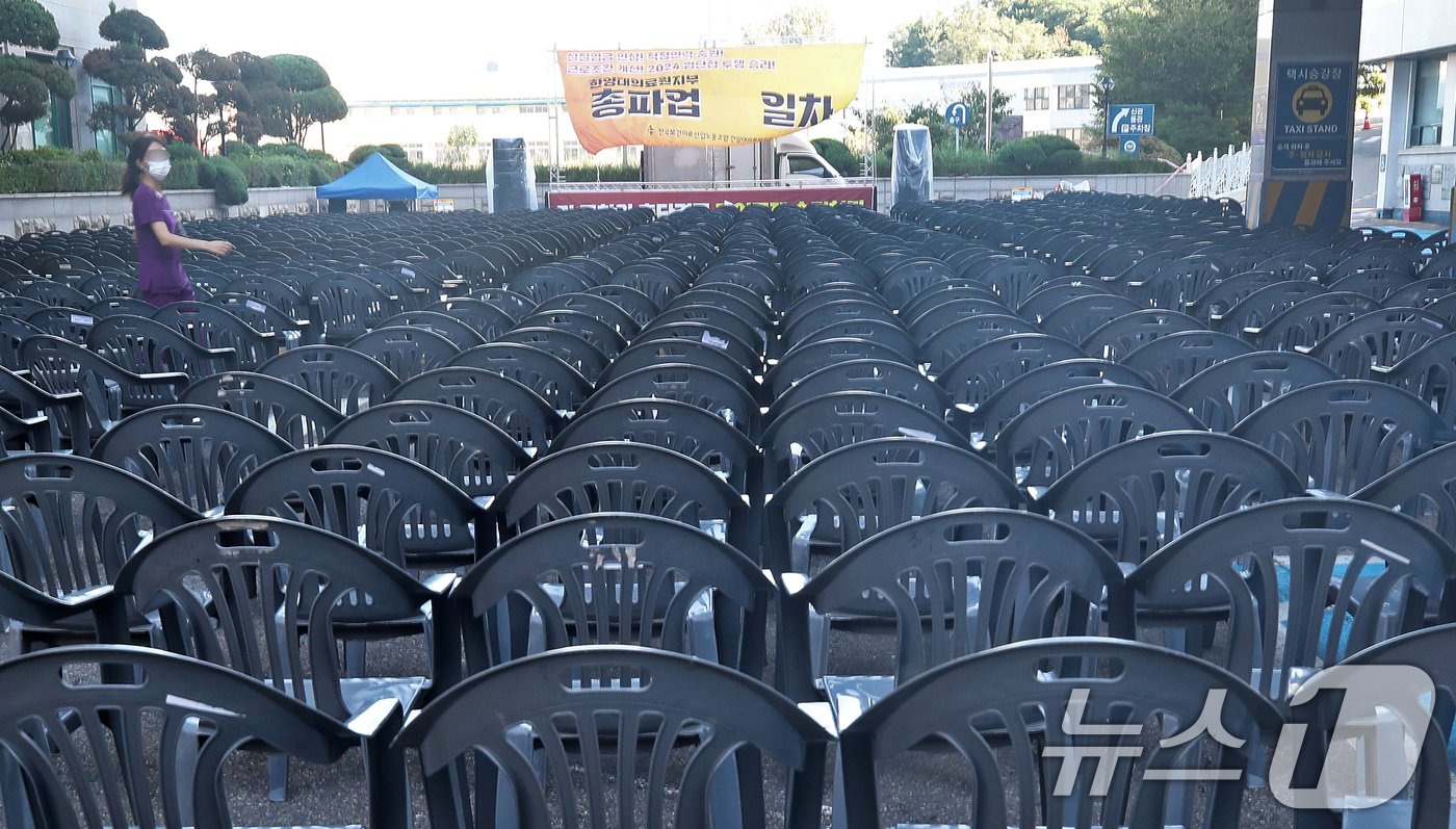 본문 이미지 - 보건의료노조가 총파업을 사실상 철회한 29일 오전 서울 성동구 한양대병원에서 한 간호사가 파업 독려 현수막이 걸린 노조의 총파업 행사장 사이를 걸어가고 있다.2024.8.29/뉴스1 ⓒ News1 오대일 기자