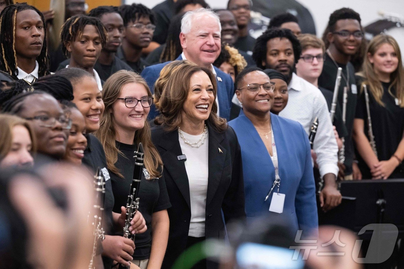 본문 이미지 - 미국 민주당 대선 후보인 카멀라 해리스 부통령이 28일 (현지시간) '선벨트' 경합주 버스 유세 중 조지아주 하인즈빌의 고등학교 밴드부원들을 만나 러닝메이트 팀 월즈 미네소타 주지사와 포즈를 취하고 있다. 2024.08.29 ⓒ AFP=뉴스1 ⓒ News1 우동명 기자
