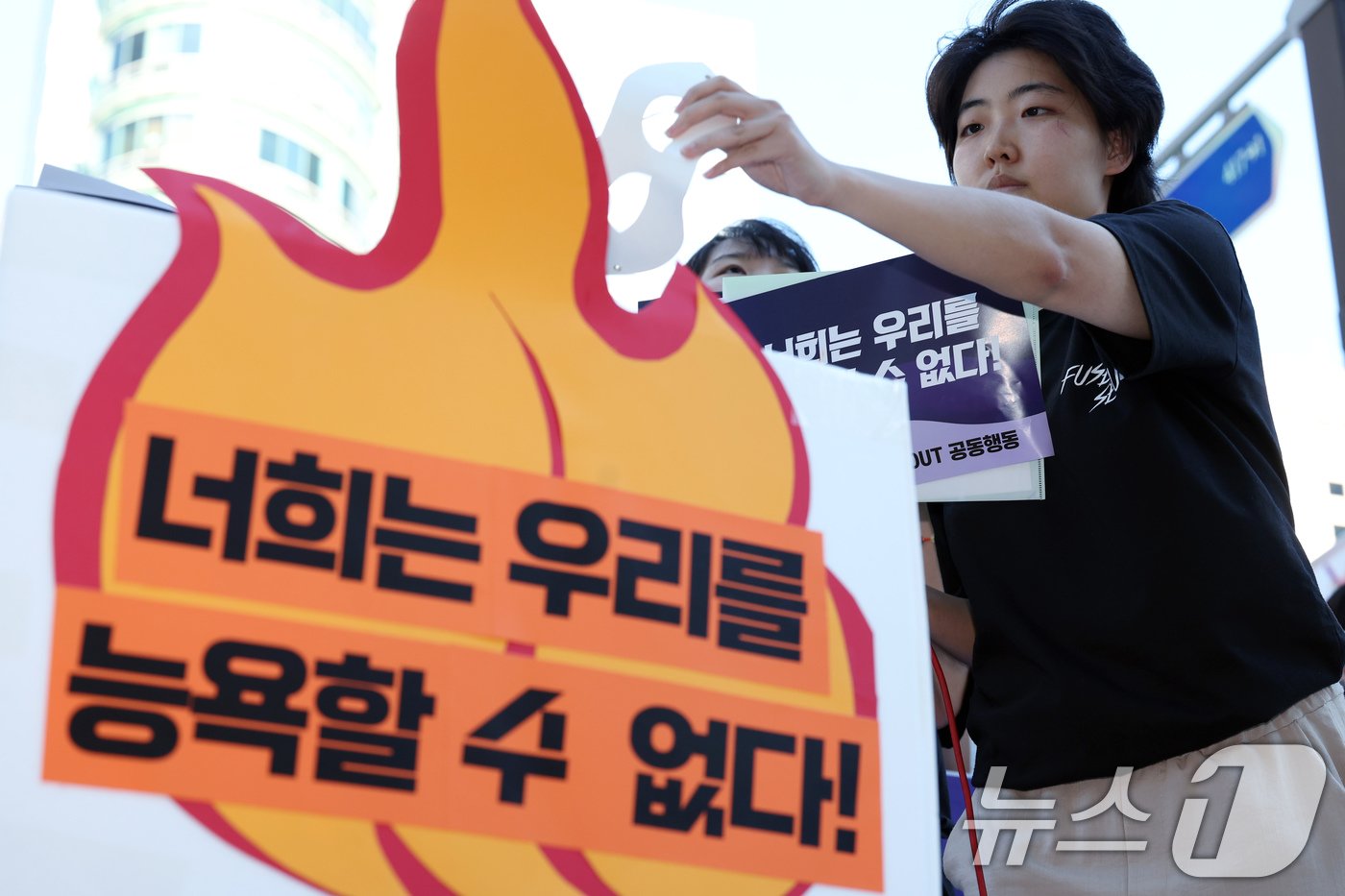 본문 이미지 - 서울여성회 활동가와 서울여성회 페미니스트 대학생 연합동아리 학생 등이 29일 오후 서울 강남역 10번 출구 앞에서 가진 딥페이크 성범죄 규탄 여성 시민·대학생 긴급 기자회견에서 자유의 쓰레기통에 가면을 던져 버리는 퍼포먼스를 펼치고 있다.  2024.8.29/뉴스1 ⓒ News1 박정호 기자