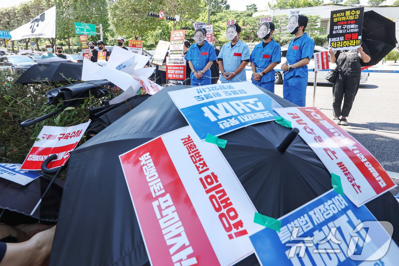 본문 이미지 - 김동식 인터파크커머스 대표(왼쪽부터)와 구영배 큐텐그룹 대표, 류화현 위메프 대표, 류광진 티몬 대표의 가면을 쓰고 수의를 입은 '티메프 사태' 피해자들이 30일 오전 서울 서초구 서울중앙지방검찰청 앞에서 열린 '검은우산 집회'에 참가해 책임자들의 구속수사를 촉구하고 있다. 이날 참가자들은 정부에 실효성 있는 구제방안 마련과 특별법 제정을 촉구했다. 2024.8.30/뉴스1 ⓒ News1 민경석 기자