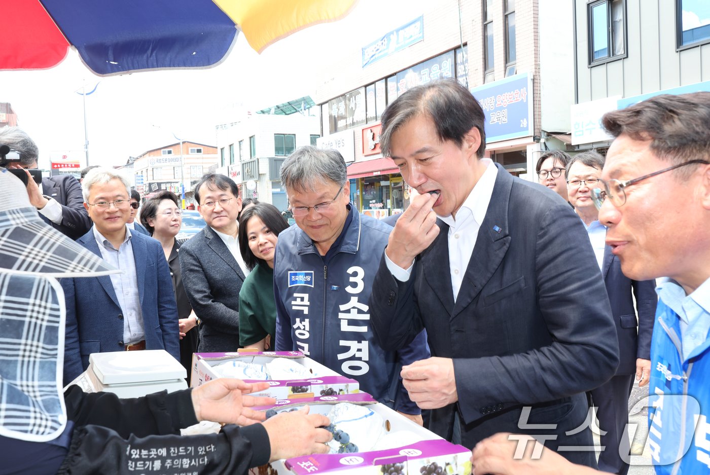 본문 이미지 - 조국 조국혁신당 대표가 30일 전남 곡성군 옥과터미널앞에서 포도상인과 인사를 나누며 포도를 먹어보고 있다.2024.8.30/뉴스1 ⓒ News1 김태성 기자