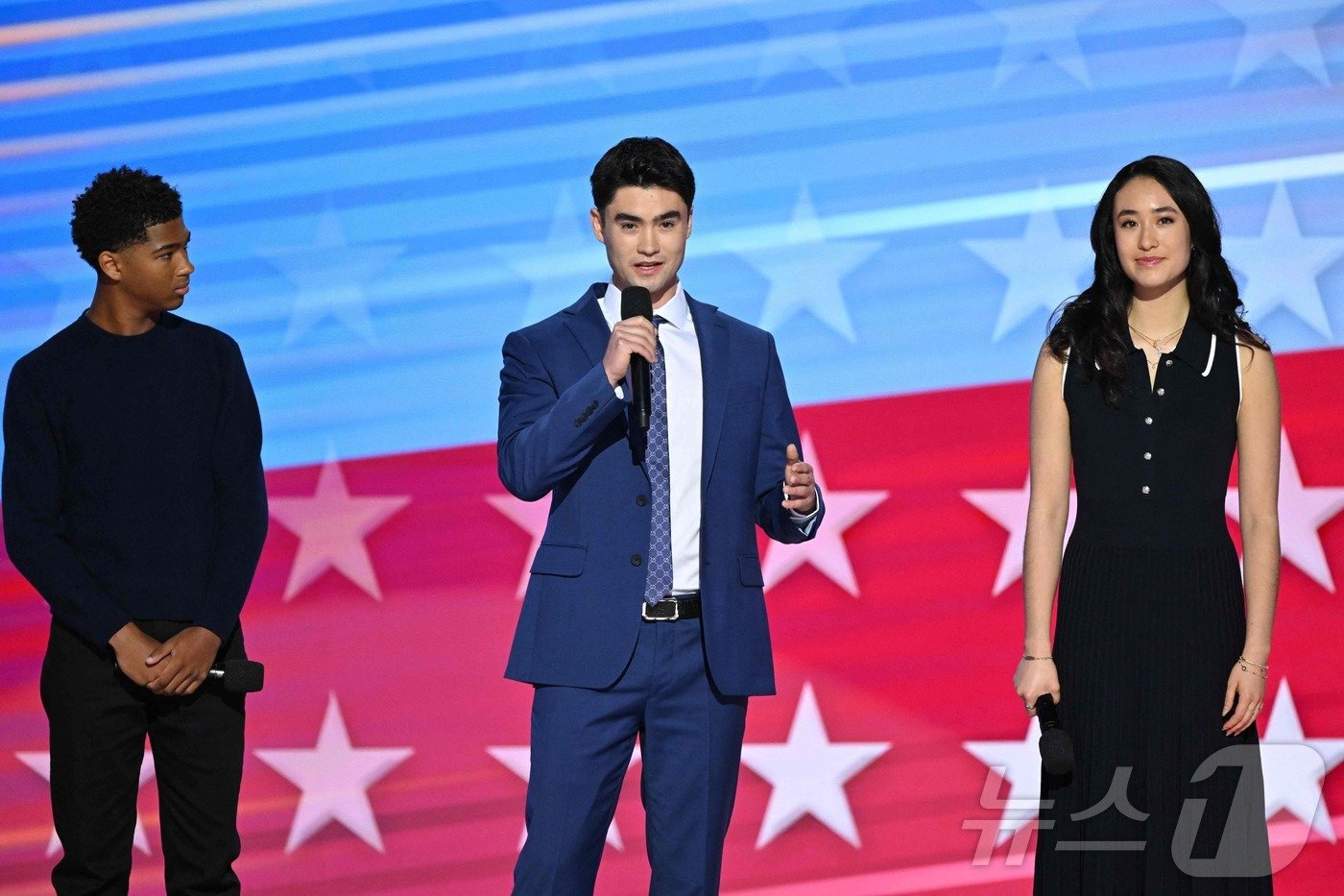 본문 이미지 - 지난 21일 일리노이주 시카고 유나이티드 센터에서 열린 민주당 전당대회(DNC) 셋째 날 무대에서 카멀라 해리스 부통령의 조카들인 (왼쪽부터) 알렉산더 허들린, 재스퍼 엠호프, 아덴 엠호프가 연설하고 있다. 재스퍼와 아덴은 해리스 부통령의 남편 더글러스 엠호프의 동생인 앤드루 엠호프와 한국계 부인 주디 리 박사가 낳은 자녀들이다. ⓒ AFP=뉴스1 류정민 특파원