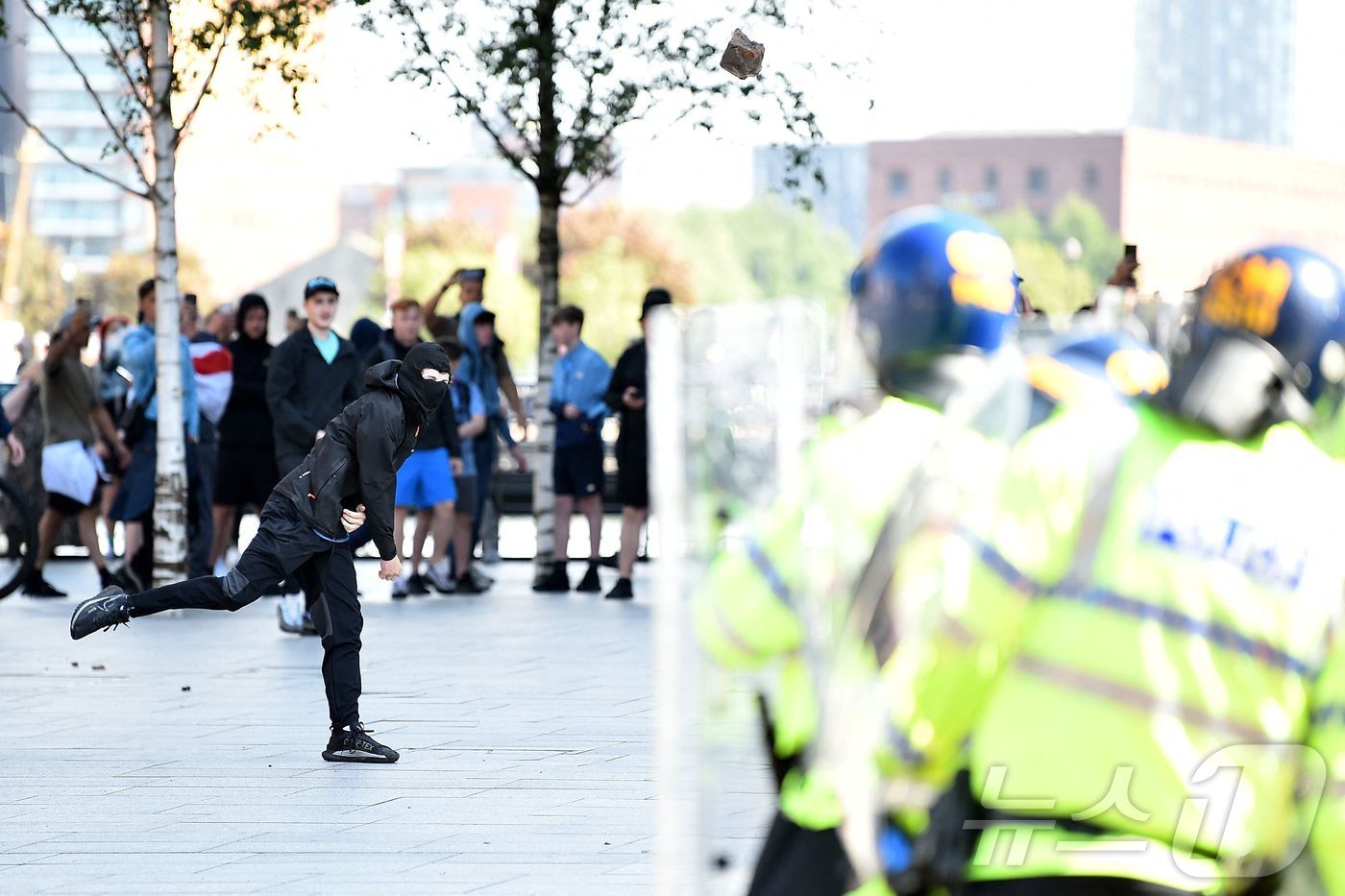 본문 이미지 - 3일(현지시간) 영국 리버풀에서 한 시위자가 경찰을 향해 벽돌을 던지고 있다. 최근 영국에서는 어린이 댄스 교실을 노린 흉기 범죄로 아동 3명이 사망한 후로 극렬한 시위가 이어지고 있다. 2024.08.03/ ⓒ AFP=뉴스1 ⓒ News1 권진영 기자