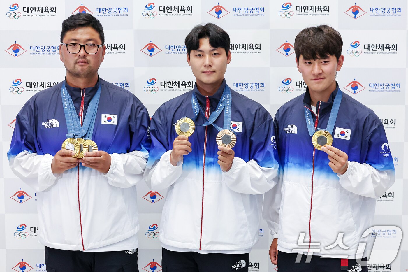 본문 이미지 - 2024 파리올림픽 남자 양궁 대표팀 이우석&#40;왼쪽부터&#41;과 김우진, 김제덕이 인천국제공항을 통해 귀국해 금메달을 들고 포즈를 취하고 있다. 2024.8.6/뉴스 ⓒ News1 민경석 기자