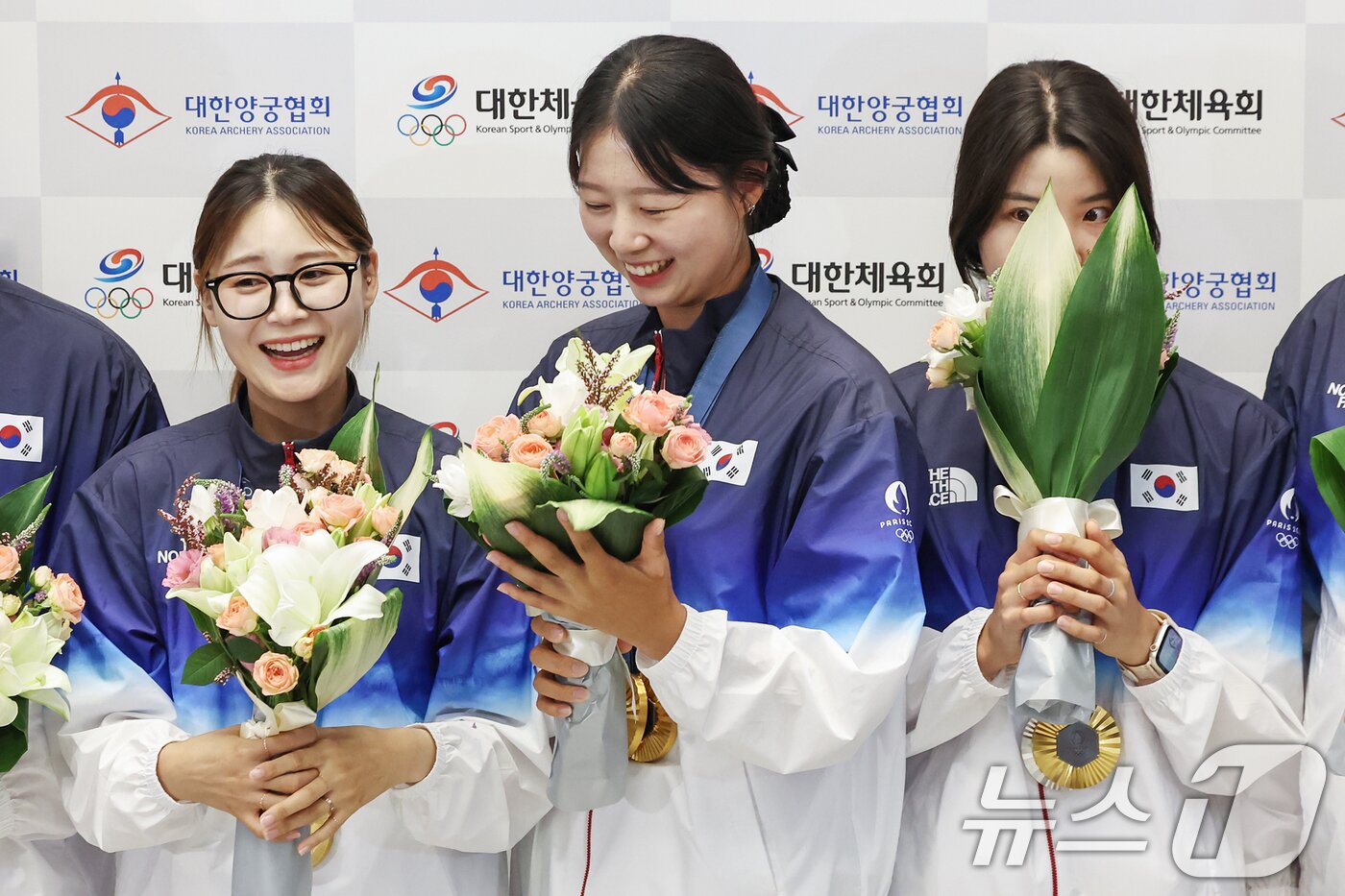 본문 이미지 - 2024 파리올림픽 여자 양궁 개인·단체 및 혼성 단체전에서 금메달을 수확한 전훈영&#40;왼쪽부터&#41;과 임시현, 남수현이 인천국제공항을 통해 귀국해 꽃다발을 받고 기뻐하고 있다. 2024.8.6/뉴스1 ⓒ News1 민경석 기자