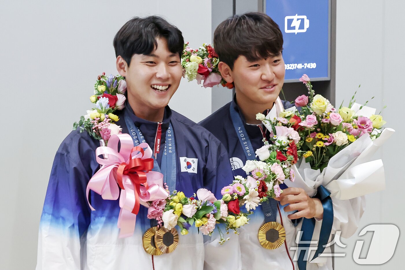 본문 이미지 - 2024 파리올림픽 남자 양궁 단체전에서 금메달을 수확한 이우석&#40;왼쪽&#41;과 김제덕이 인천국제공항을 통해 귀국해 꽃목걸이를 함께 걸고 있다. 2024.8.6/뉴스1 ⓒ News1 민경석 기자
