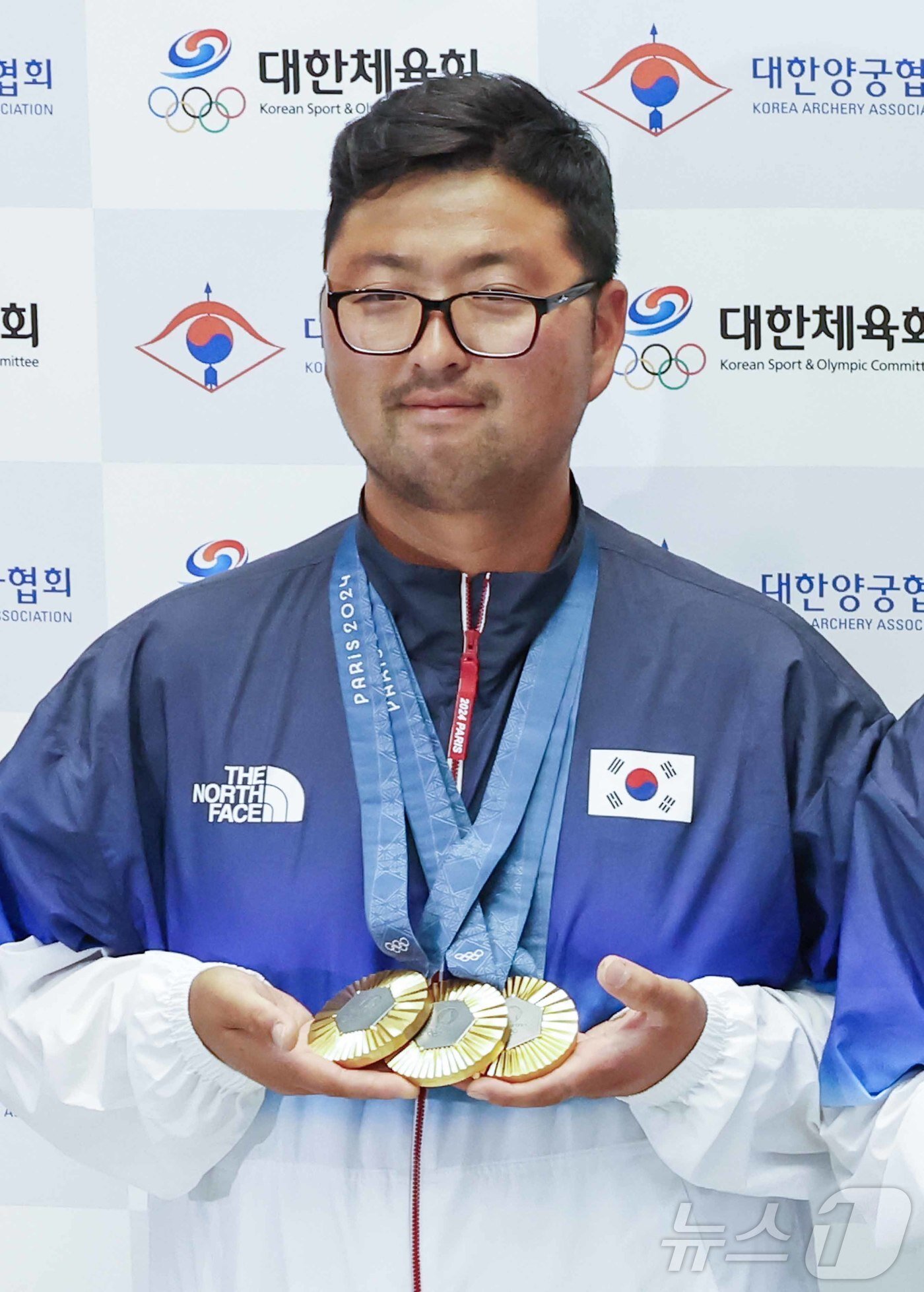 본문 이미지 - 2024 파리올림픽 남자 양궁 3관왕에 오른 김우진이 인천국제공항을 통해 귀국해 금메달을 목에 걸고 포즈를 취하고 있다. 2024.8.6/뉴스1 ⓒ News1 민경석 기자