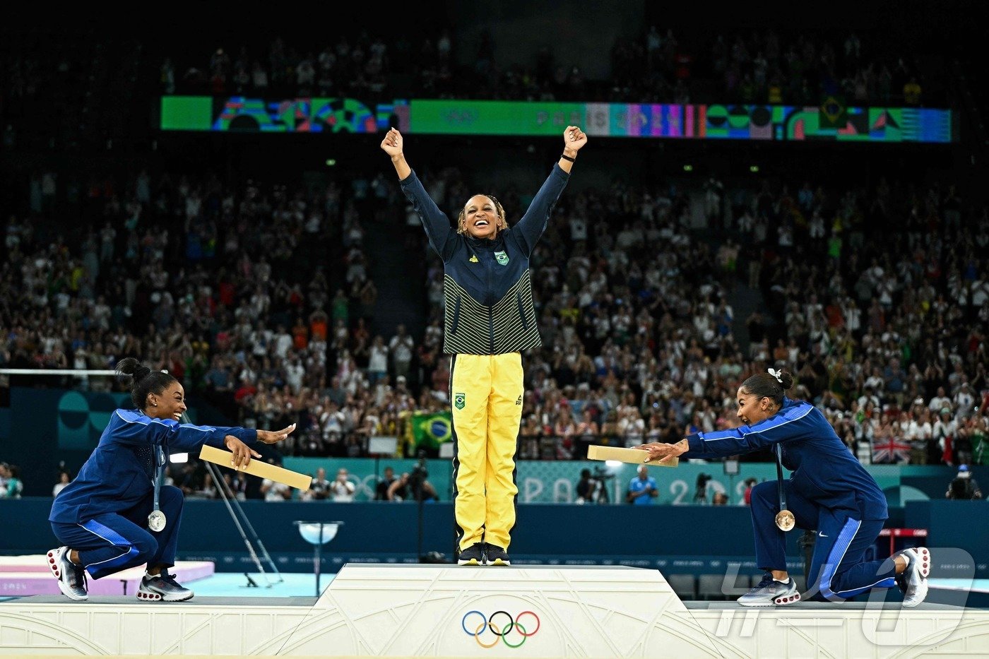 본문 이미지 - 시몬 바일스(왼쪽)과 조던 차일스(오른쪽)가 레베카 안드라드를 향해 세리머니를 펼치고 있다 ⓒ AFP=뉴스1