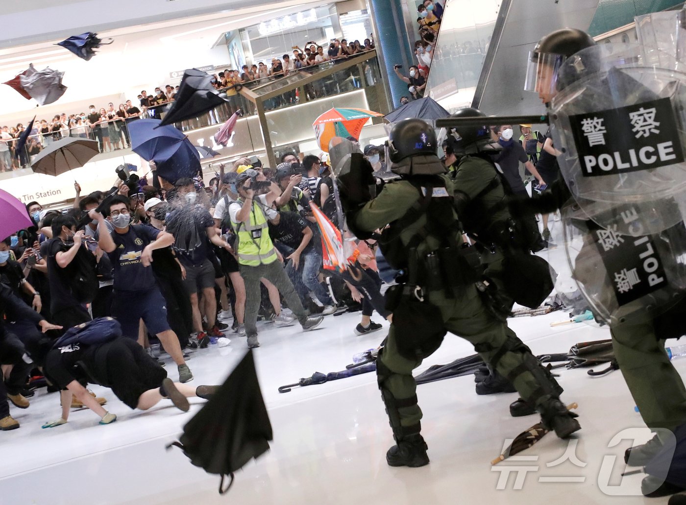 본문 이미지 - 홍콩에서 열린 시위를 진압하기 위해 경찰이 쇼핑몰 안에서 후추 스프레이를 사용해 민주화 운동가들을 해산시키고 있다. 2019.07.14. ⓒ 로이터=뉴스1 ⓒ News1 신은빈 기자