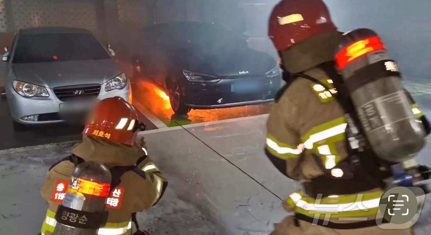 6일 충남 금산군 금산읍 한 주차타워에 주차돼 있던 전기차에 불이나 소방대원이 화재를 진압하고 있다. &#40;금산소방서 제공&#41; 2024.8.6/뉴스1