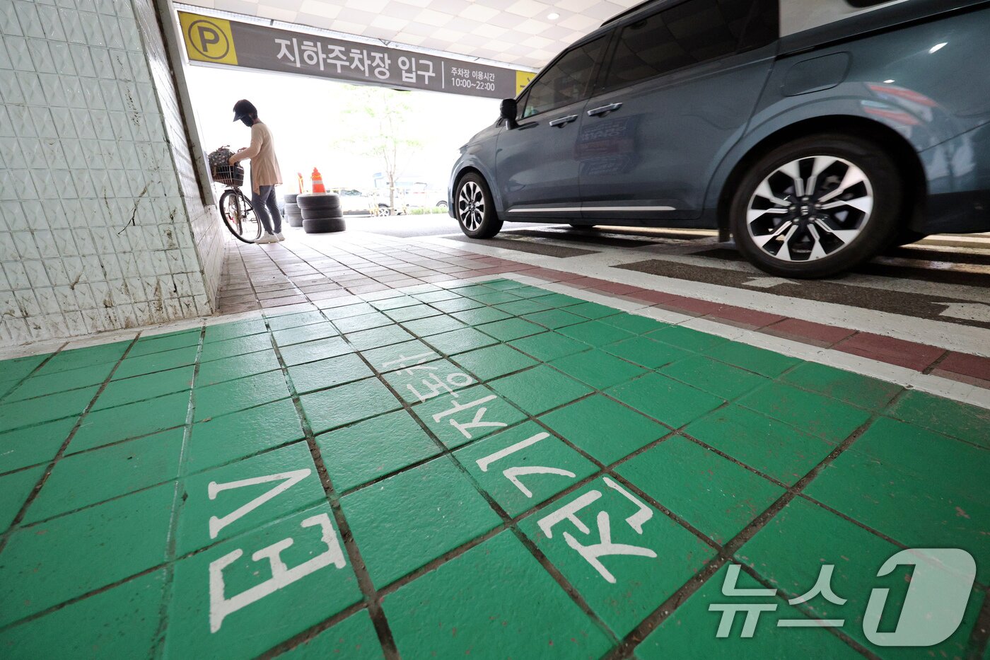 본문 이미지 - 7일 오전 경기 과천의 한 상업시설 지하주차장 앞 전기차 충전소 앞으로 시민과 차량이 지나가고 있다. 최근 인천 청라의 한 아파트 지하주차장에서 발생한 전기차 화재 사고 여파로 전국 곳곳의 아파트와 상업시설 지하주차장에 전기차 진입을 막는 움직임이 생기고 있다. 2024.8.7/뉴스1 ⓒ News1 장수영 기자