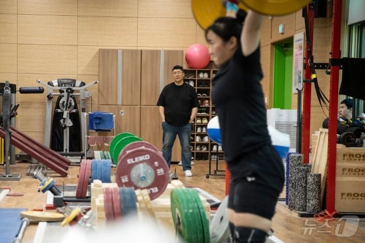 본문 이미지 - 전직 역도 선수였던 전상균이 6월 한국 경산에서 딸 전희수가 훈련하는 것을 지켜보고 있다.(뉴욕타임스 제공)/뉴스1 