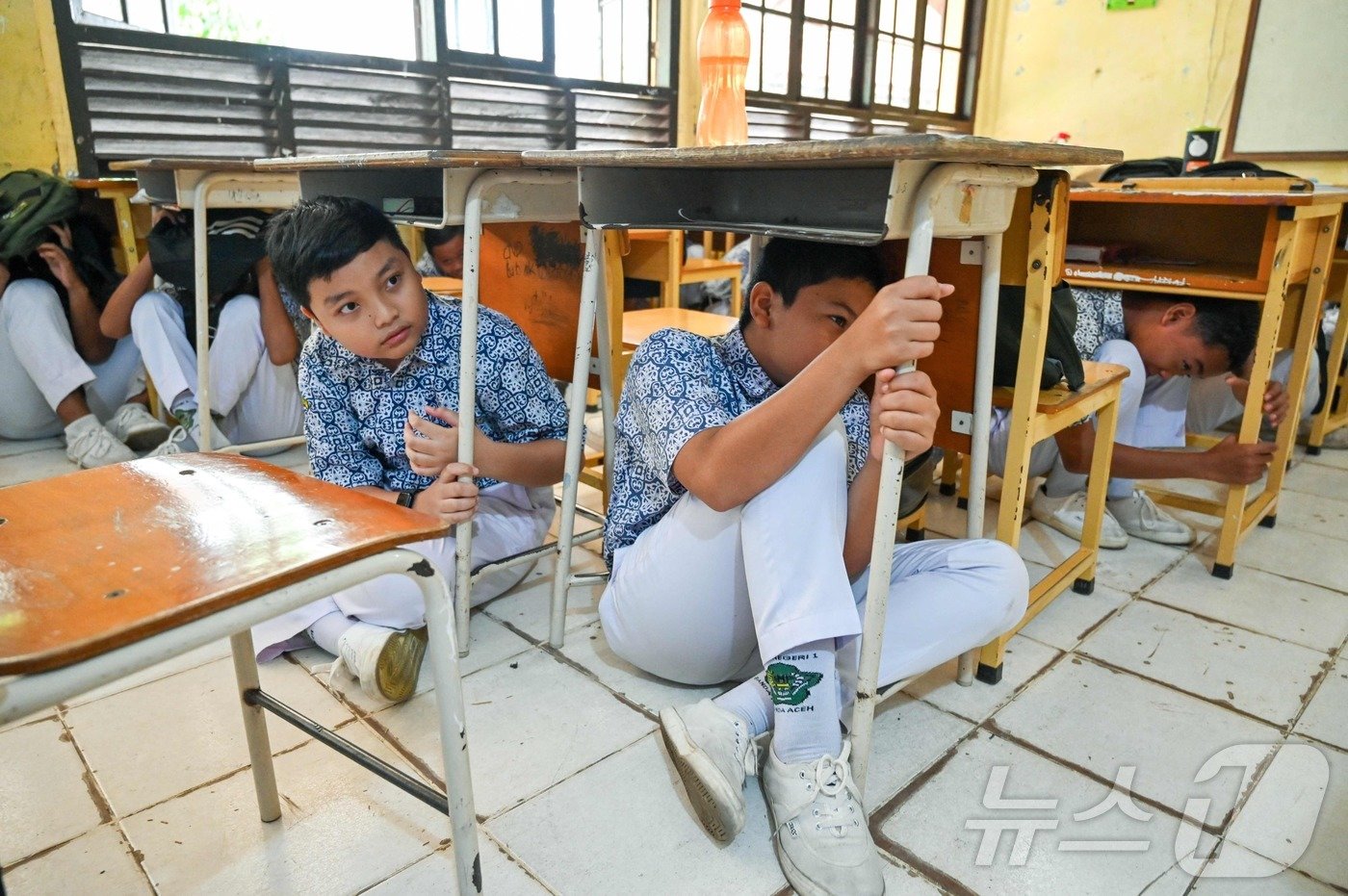 본문 이미지 - '불의 고리' 인도네시아 반다아체의 중학생들이 7일 지진과 해일에 대비한 재난대피 훈련을 하고 있다. 지진·해일이 잦은 반다아체에서는 재난대응이 교과목중 하나이다. 2024.08.07 ⓒ AFP=뉴스1 ⓒ News1 신은빈기자
