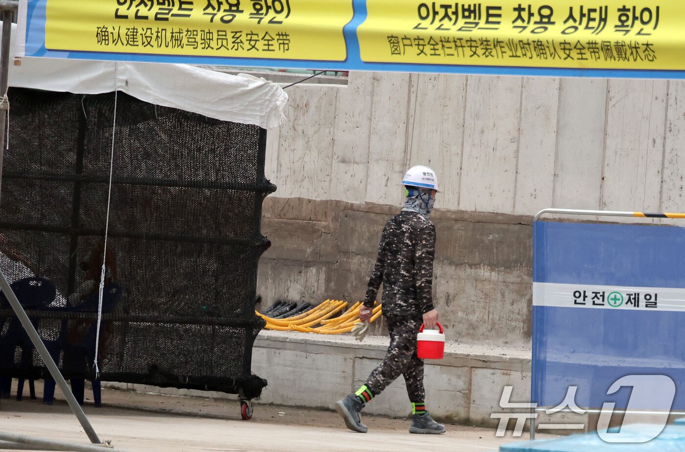 본문 이미지 -  건설현장에서 한 근로자가 음료를 들고 이동하고 있다. &#40;공동취재&#41;  ⓒ News1 허경 기자