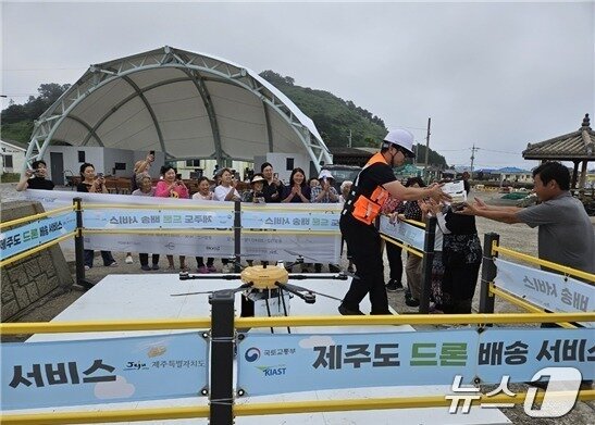 본문 이미지 - 비양도 주민들이 드론으로 배송된 치킨을 받고 있다(제주도 제공)