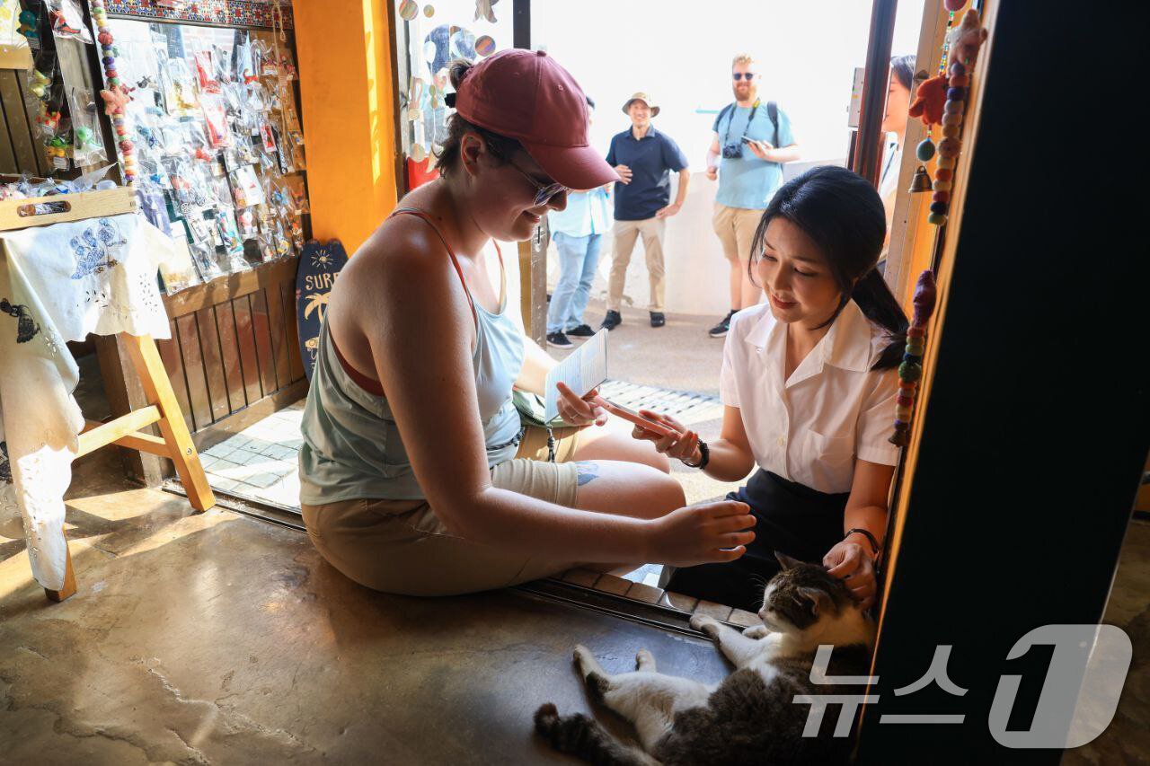본문 이미지 - 김건희 여사가 지난 7일 6·25 전쟁 당시 피란민들이 모여 살던 마을이었던 흰여울문화마을에서 한 외국인과 대화를 나누고 있다. 윤석열 대통령과 함께 여름휴가를 보내고 있는 부인 김건희 여사가 부산을 이틀 연속 방문한 것으로 전해졌다. 앞서 지난 6일 김 여사는 부산 '명란브랜드연구소'와 깡통시장을 방문했다. (대통령실 제공) 2024.8.8/뉴스1 ⓒ News1 박지혜 기자