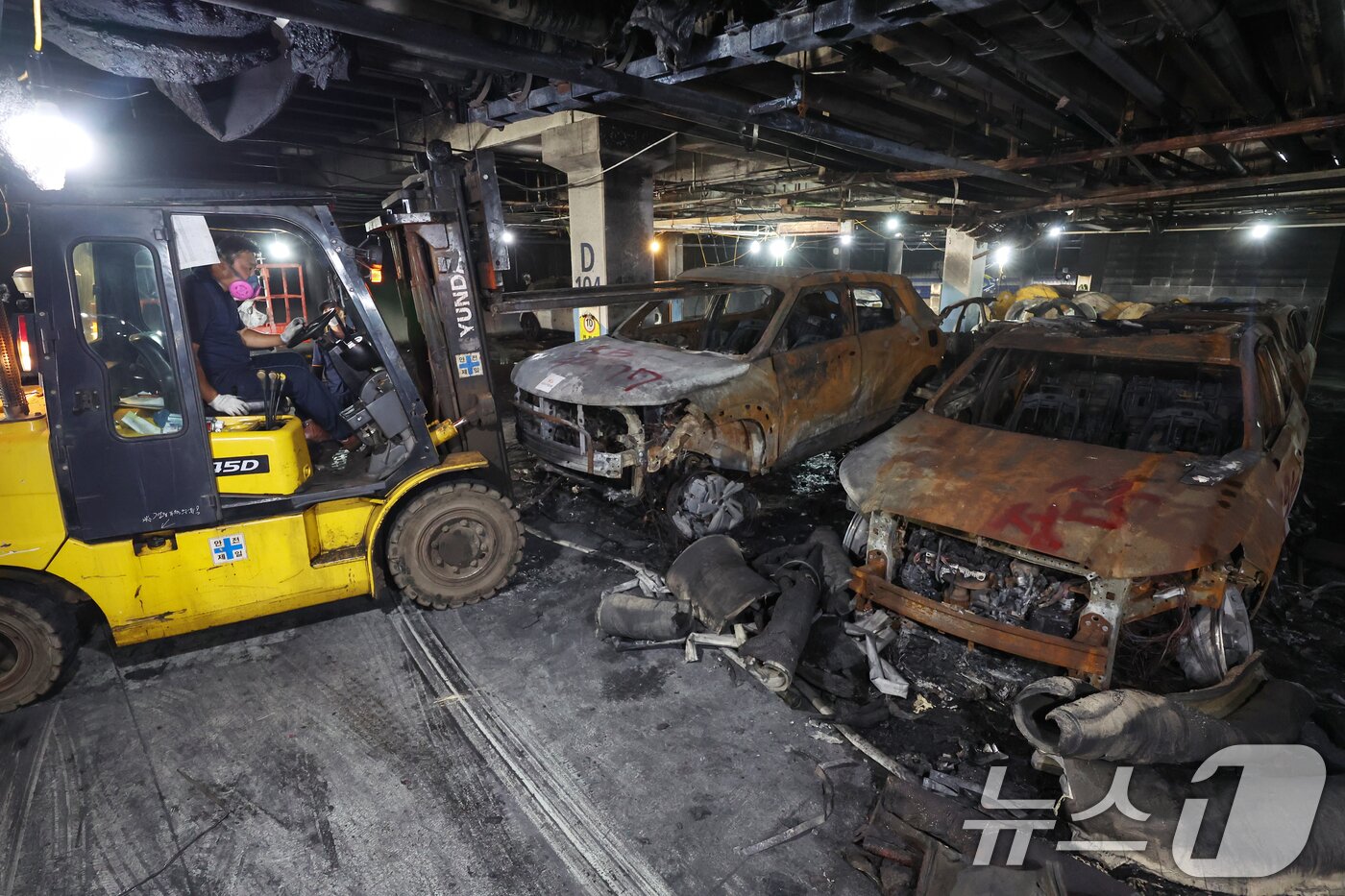 본문 이미지 - 8일 인천 서구 청라동의 한 아파트 단지 지하주차장에서 지난 1일 발생한 전기차 화재 사고로 인해 불에 탄 차량을 지게차가 들어올리고 있다. 2024.8.8/뉴스1 ⓒ News1 민경석 기자