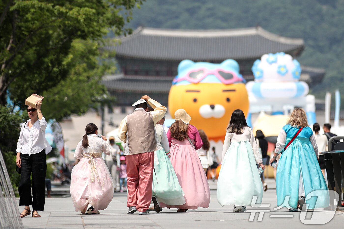 본문 이미지 - 서울 세종대로 광화문광장에서 관광객과 시민들이 종이가방 등을 이용해 햇빛을 가리며 걷고 있다. /뉴스1 ⓒ News1 이승배 기자