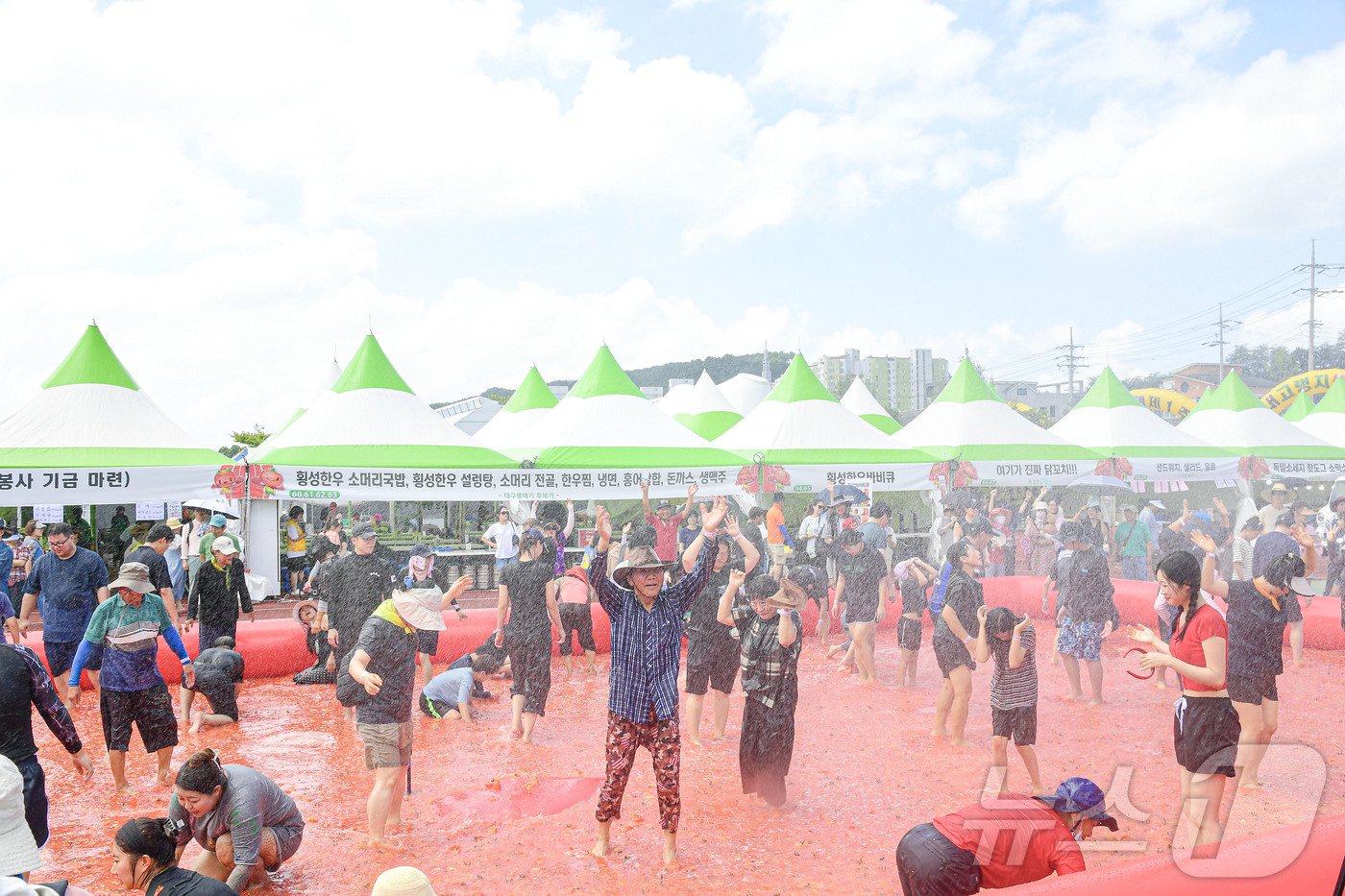 제13회 강원 횡성 둔내고랭지토마토축제가 9일 개막한 가운데 둔내종합체육공원에 마련된 대규모 토마토 풀장에서 관광객들이 토마토 속에 숨겨진 금반지 등 경품을 찾으며 축제를 즐기고 있다. ‘대한민국 최고의 토마토와 함께하는 한여름 가족축제’를 주제로 한 이번 축제는 오는 11일까지 이어진다.&#40;횡성군 제공&#41; 2024.8.9./뉴스1 ⓒ News1 이종재 기자