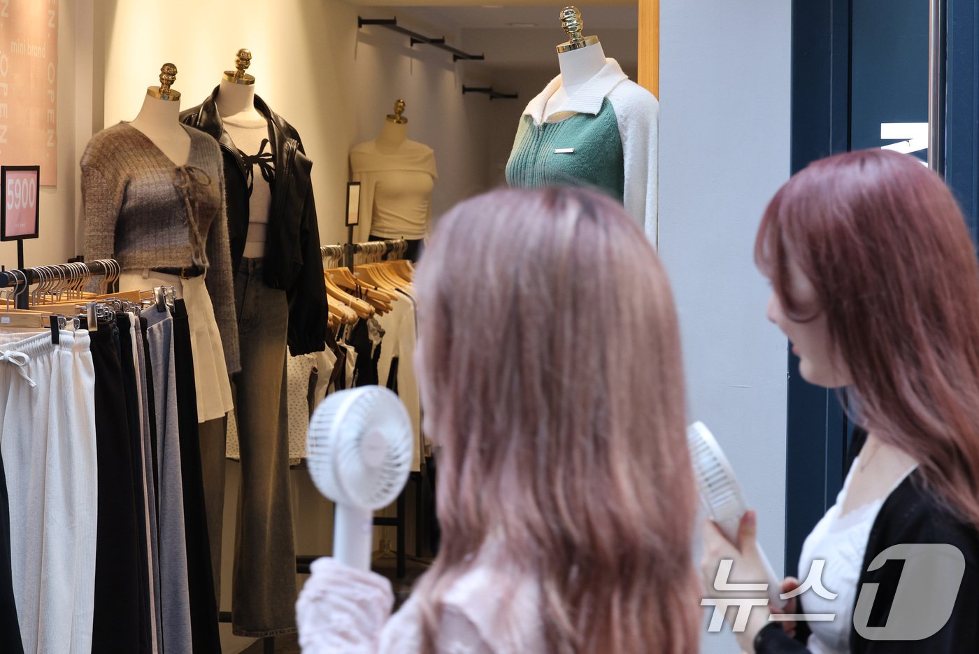 본문 이미지 - 서울 낮 최고기온이 35도까지 오른 10일 오후 서울 명동거리에서 가벼운 옷차림을 한 외국인 관광객이 가을옷이 걸린 쇼윈도를 지나가고 있다. 기상청은 역대급 수준의 9월 폭염이 이번 주 후반까지 이어질 것으로 예보했다. 2024.9.10/뉴스1 ⓒ News1 신웅수 기자