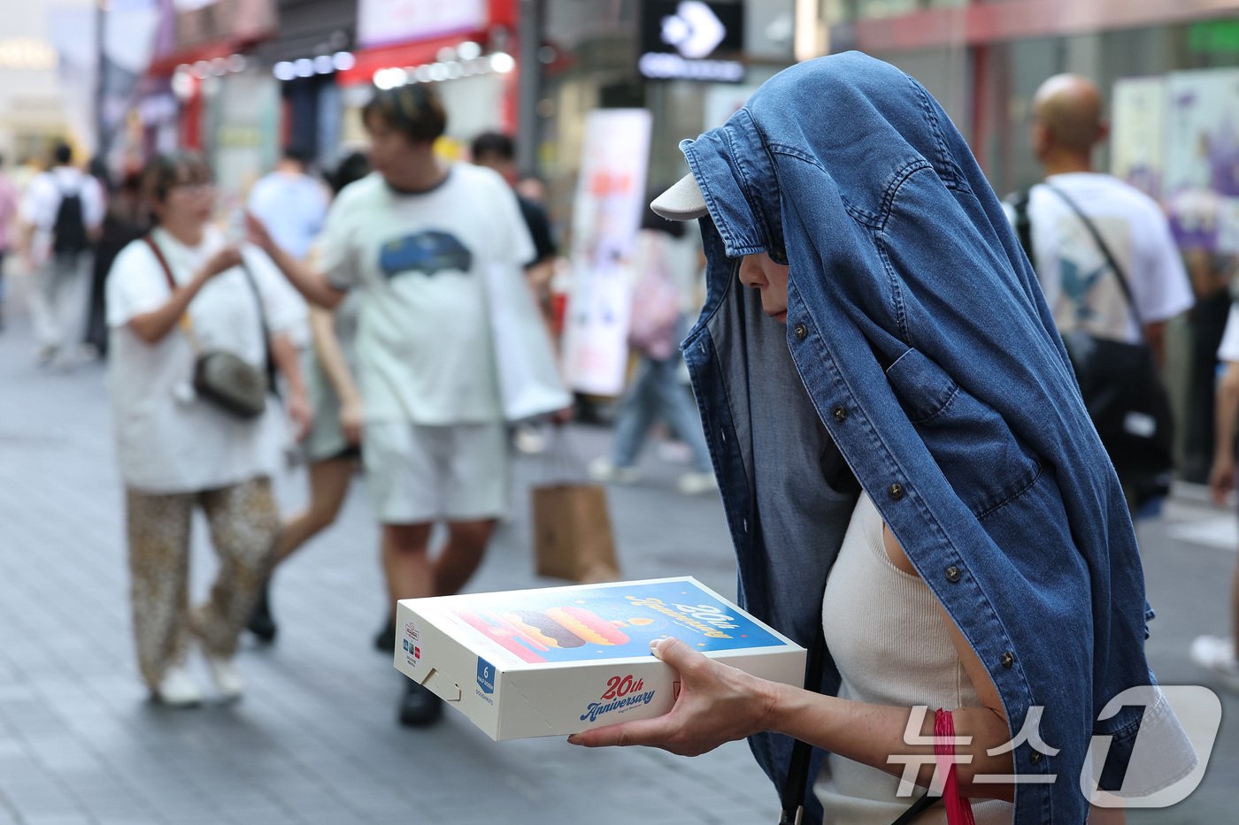 서울 낮 최고기온이 35도까지 오른 10일 오후 서울 명동거리에서 가벼운 옷차림을 한 외국인 관광객이 겉옷으로 햇빛을 가리고 있다. 기상청은 역대급 수준의 9월 폭염이 이번 주 후반까지 이어질 것으로 예보했다. 2024.9.10/뉴스1 ⓒ News1 신웅수 기자