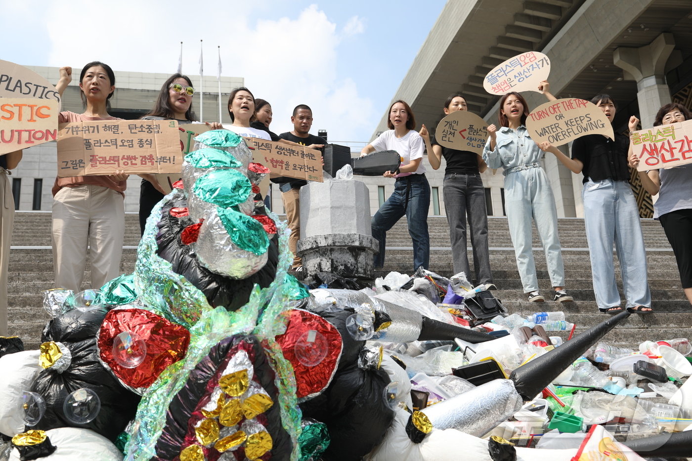 본문 이미지 - 환경단체 플뿌리연대(플라스틱 문제를 뿌리 뽑는 연대)가 11일 오전 서울 종로구 세종문화회관 앞에서 플라스틱 생산 감축을 촉구하는 퍼포먼스를 하고 있다. 2024.9.11/뉴스1 ⓒ News1 유수연 기자