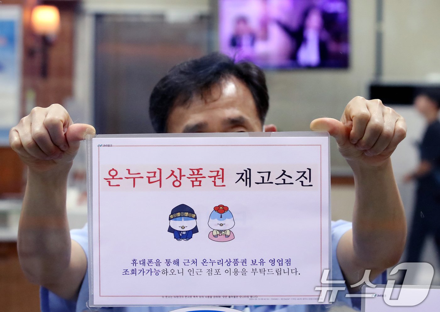 본문 이미지 - 대구 중구의 한 iM뱅크 영업점에서 청원경찰이 '온누리상품권 재고소진' 안내문을 붙이고 있다. /뉴스1 ⓒ News1 공정식 기자