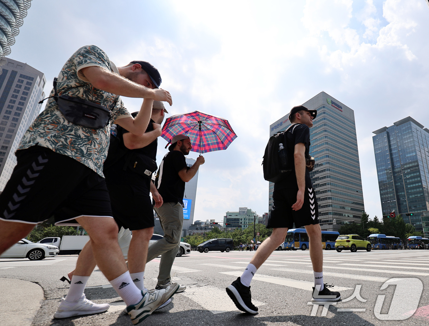 (서울=뉴스1) 구윤성 기자 = 가을 폭염이 이어진 11일 오후 서울 광화문네거리에서 관광객들이 양산과 얼음커피를 들고 걸음을 옮기고 있다. 2024.9.11/뉴스1