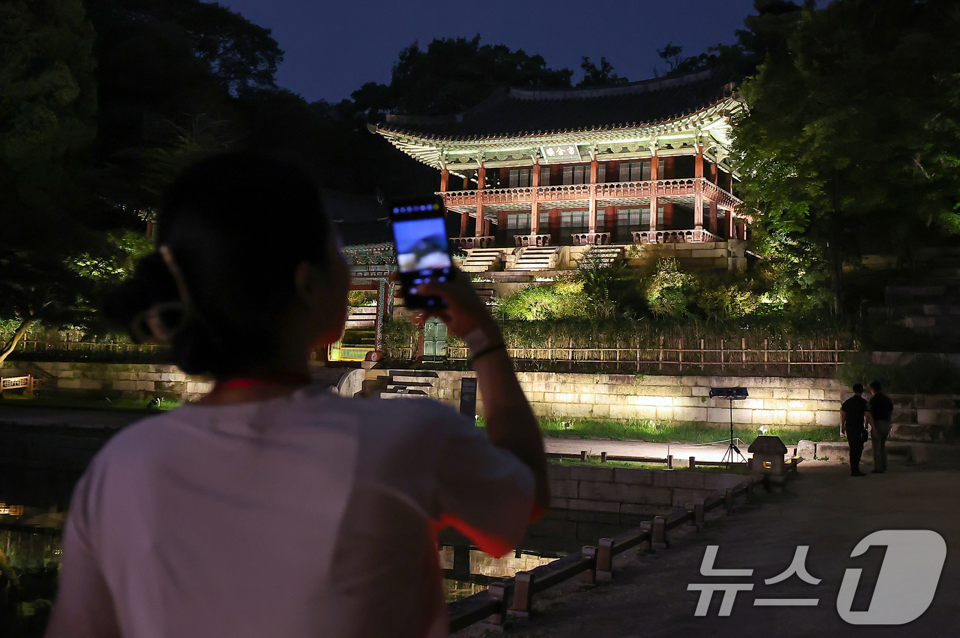 (서울=뉴스1) 김진환 기자 = 11일 오후 서울 종로구 창덕궁에서 열린 달빛기행 사전행사에서 참가자가 부용지를 관람하고 있다.국가유산청 궁능유적본부와 국가유산진흥원에서 주최하는 …